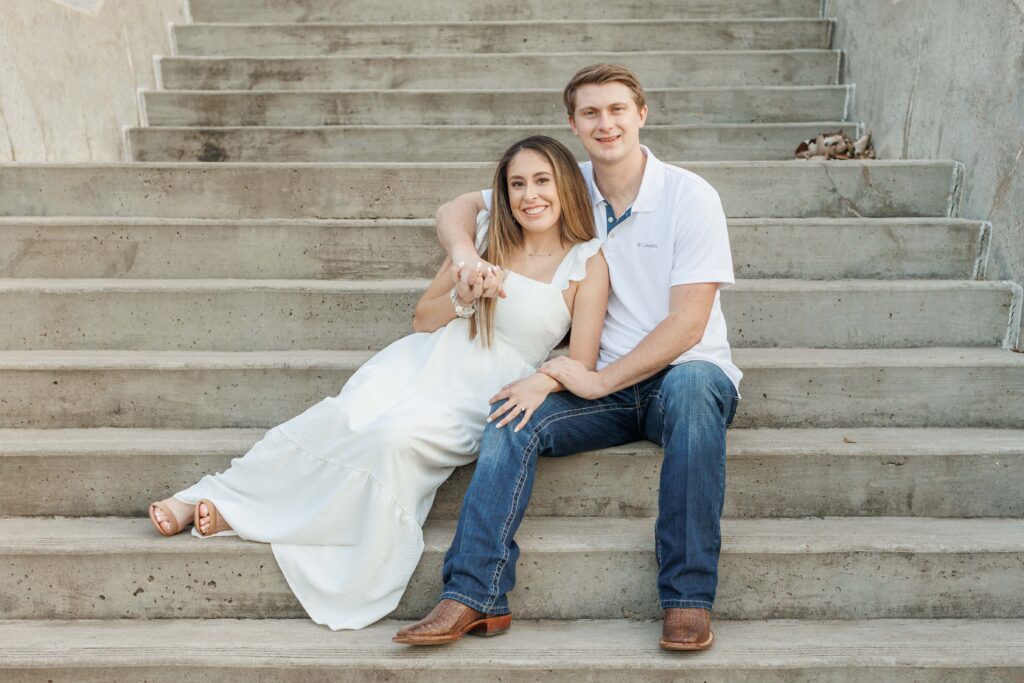 male and female couple pose for Eleanor Tinsley park engagement photos on concrete stairs