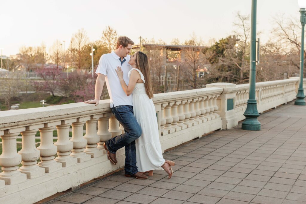 male and female couple pose for Eleanor Tinsley park engagement photos on the sabine street bridge